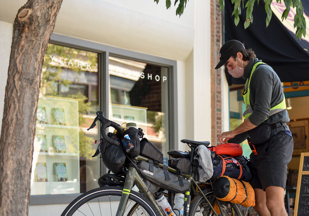 Leo Walsh zips up his belongings into the bags attached to his bike frame